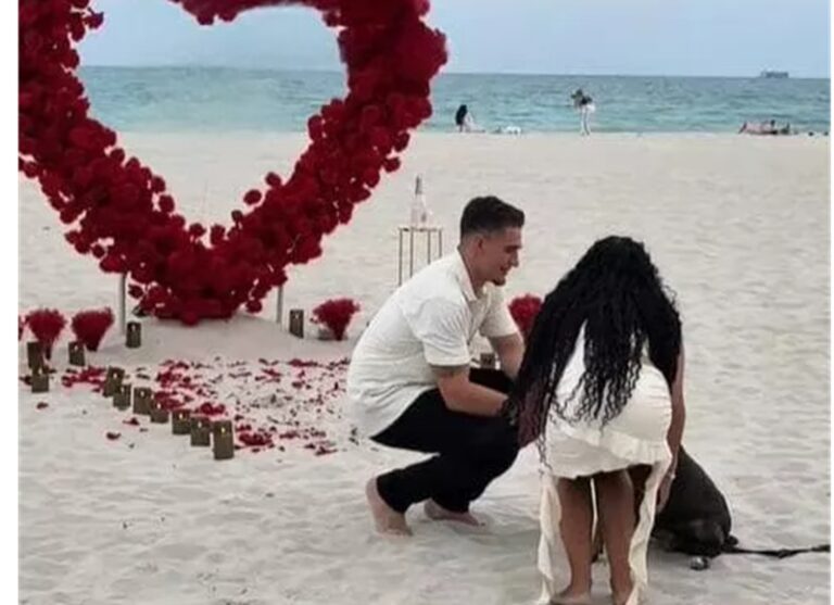 Una romantica proposta al tramonto sulla spiaggia si trasforma in un momento ancora più speciale grazie a un dolcissimo ospite a quattro zampe.