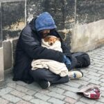 A Praga avvolge il cane con la sua unica coperta mentre attraversano il ponte a -4 °C